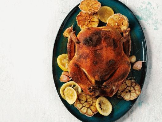 Pollo intero speziato con aglio e limoni al forno