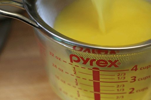 Filtrare il kurd al limone attraverso un setaccio