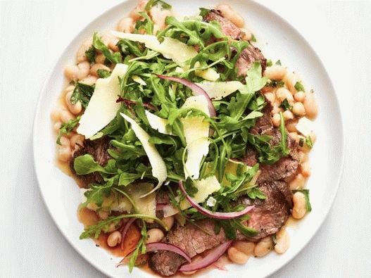 Foto di una bistecca di fianco con rosmarino e rucola