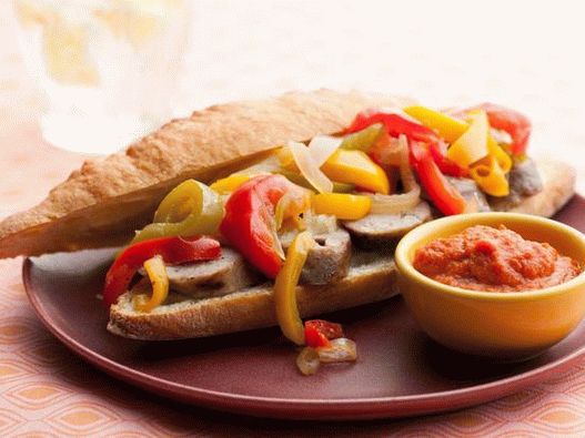 Hot dog con salsicce alla griglia, peperoni, cipolle e salsa al curry