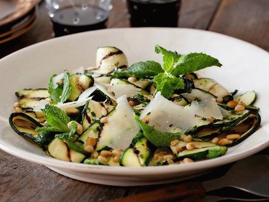 Insalata di zucchine grigliate con salsa vinaigrette al limone ed erbe aromatiche, formaggio e pinoli