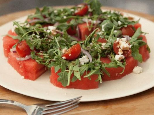 Fette di anguria con pomodorini, feta e rucola
