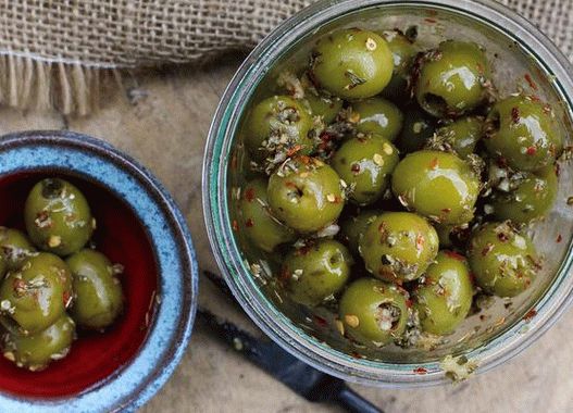Foto Olive sottaceto con rosmarino, peperoncino rosso, arancia e paprika