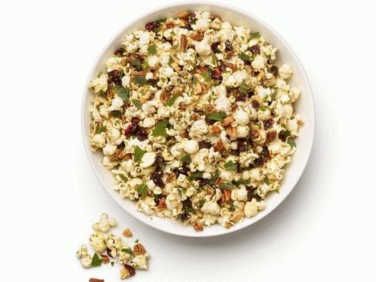 Foto popcorn speziato con noci, erbe e mirtilli rossi secchi