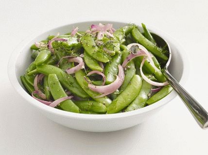 Foto piselli dolci in baccelli con cipolle rosse ed erbe