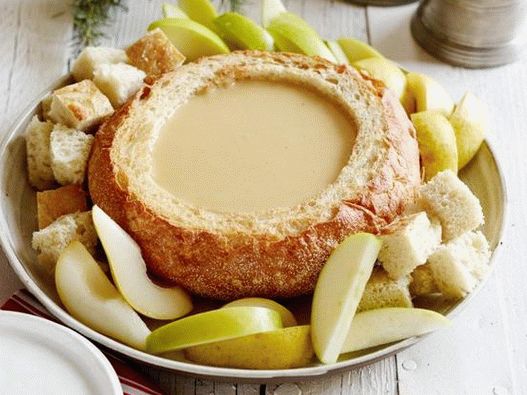 Foto Fonduta di formaggio e birra in una ciotola di pane