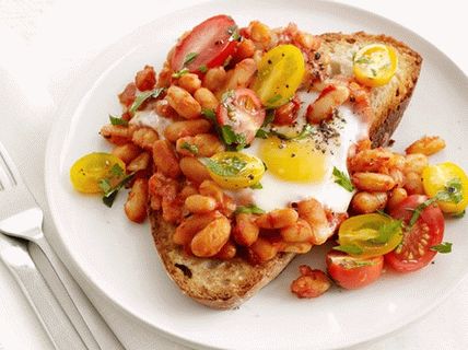 Foto di uova fritte al forno con fagioli e pomodori su toast